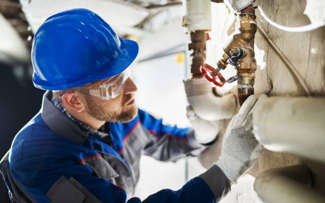 Водопроводчик подменя амортизирани тръби